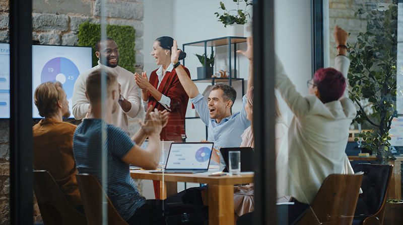 Team members celebrating in a conference room